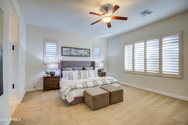 carpeted bedroom featuring multiple windows and ceiling fan