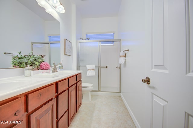 bathroom with toilet, vanity, and an enclosed shower