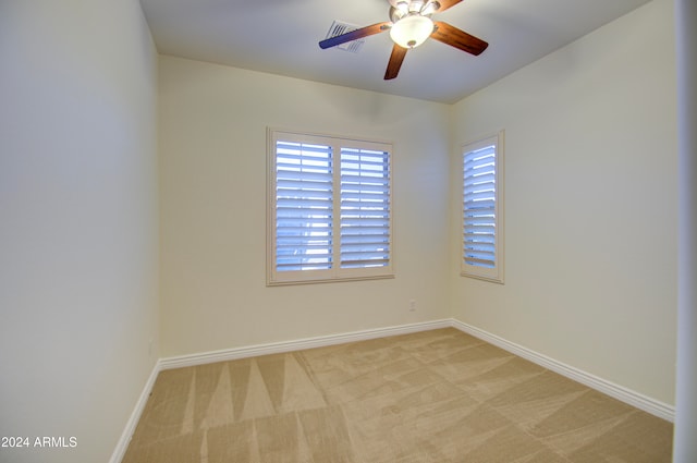 spare room featuring light carpet and ceiling fan