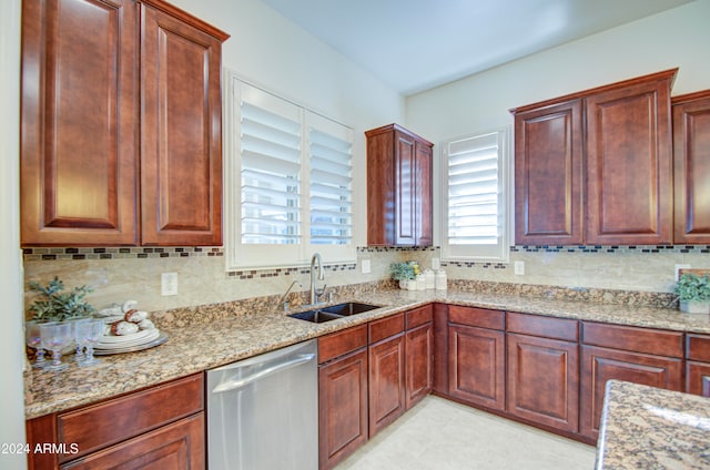 kitchen featuring dishwasher, backsplash, sink, and light stone counters