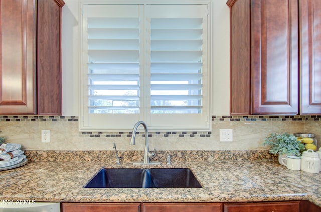 kitchen featuring sink, backsplash, and light stone countertops