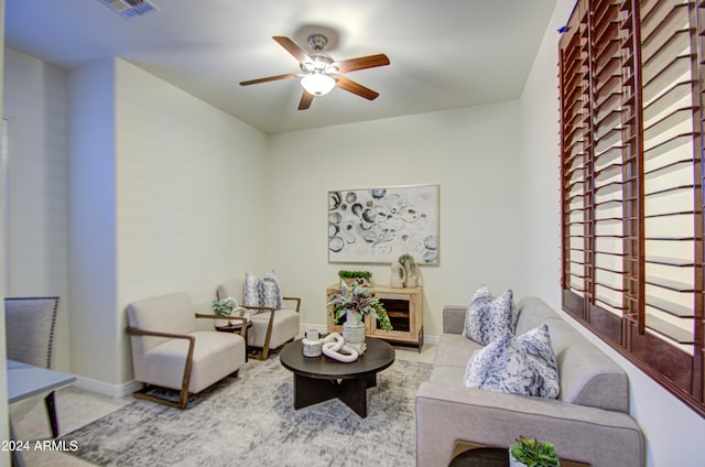 living room with ceiling fan and a fireplace