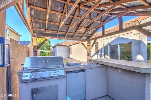 view of patio / terrace featuring exterior kitchen and a grill