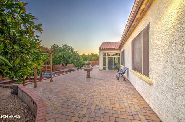 patio terrace at dusk featuring a pergola