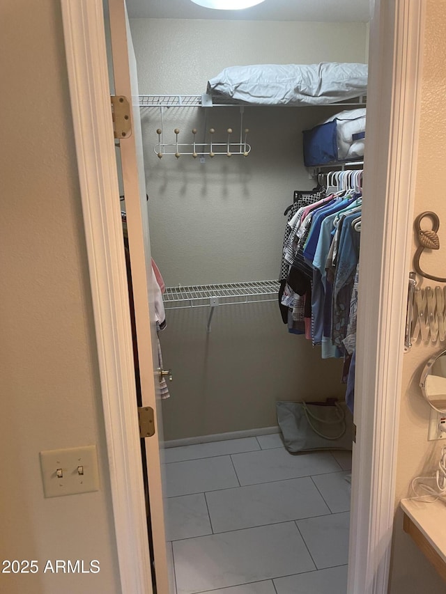 walk in closet with tile patterned flooring