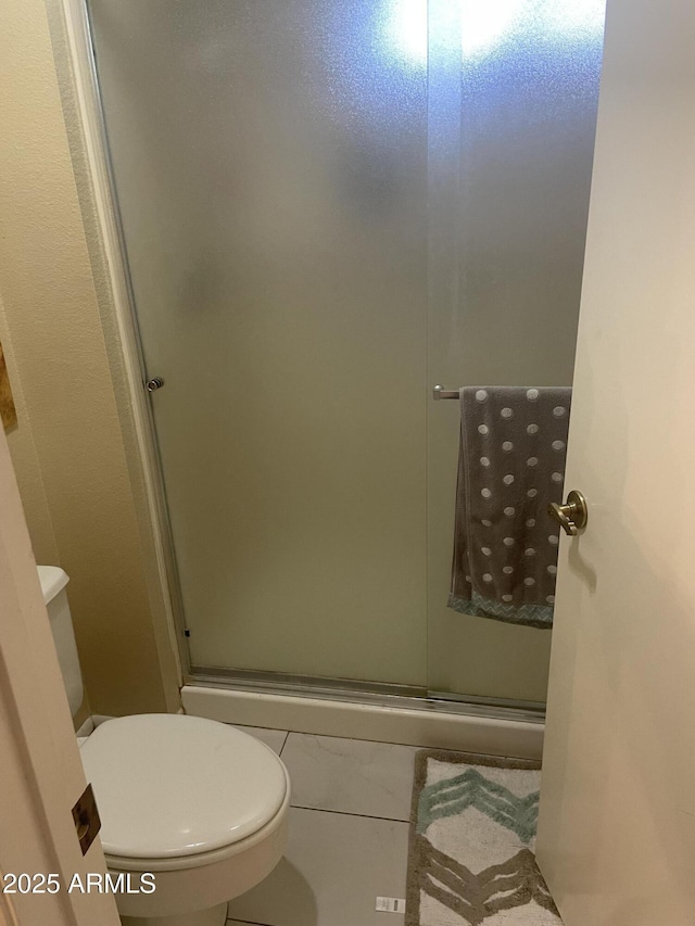 bathroom with a stall shower and toilet