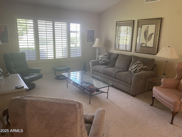 living room with carpet, visible vents, and vaulted ceiling