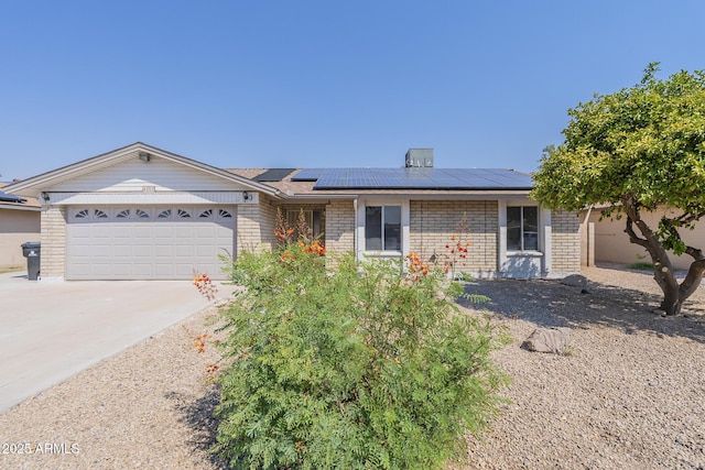 ranch-style house with solar panels and a garage