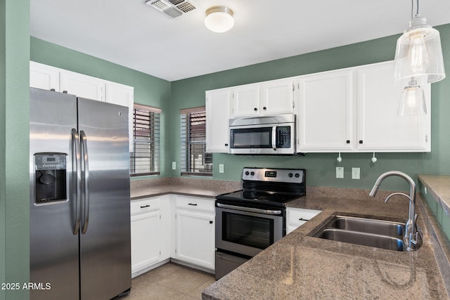 1120 N Val Vista Dr Unit 110, Gilbert, AZ 85234 - kitchen featuring appliances with stainless steel finishes, a sink, white cabinetry, decorative light fixtures, and light tile patterned floors