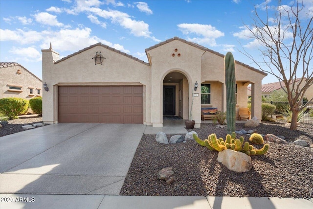 mediterranean / spanish-style home with driveway, an attached garage, a tile roof, and stucco siding