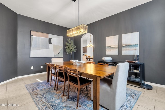 tiled dining area with baseboards, arched walkways, and a chandelier