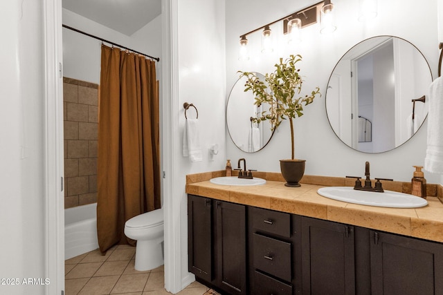 full bathroom featuring a sink, tile patterned floors, toilet, and double vanity