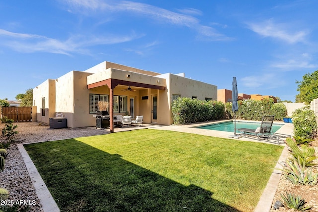 back of property with an outdoor living space, a ceiling fan, a lawn, a fenced backyard, and stucco siding