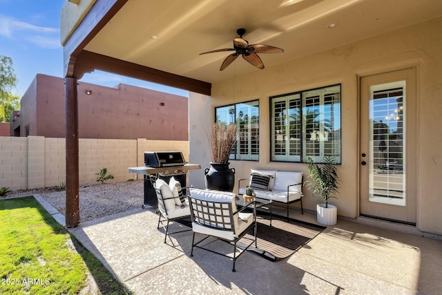 view of patio featuring area for grilling, ceiling fan, fence, and an outdoor living space