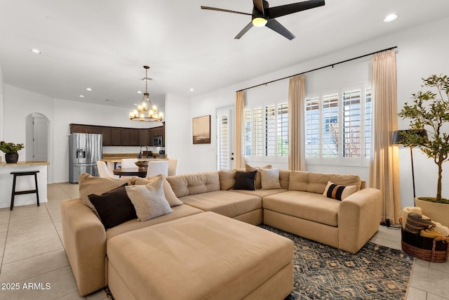 living room featuring arched walkways, ceiling fan with notable chandelier, recessed lighting, and light tile patterned flooring