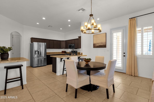dining space featuring arched walkways, visible vents, an inviting chandelier, and recessed lighting
