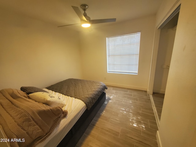 bedroom featuring ceiling fan, wood-type flooring, and a closet