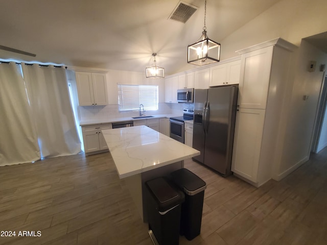 kitchen featuring pendant lighting, a center island, sink, white cabinetry, and stainless steel appliances