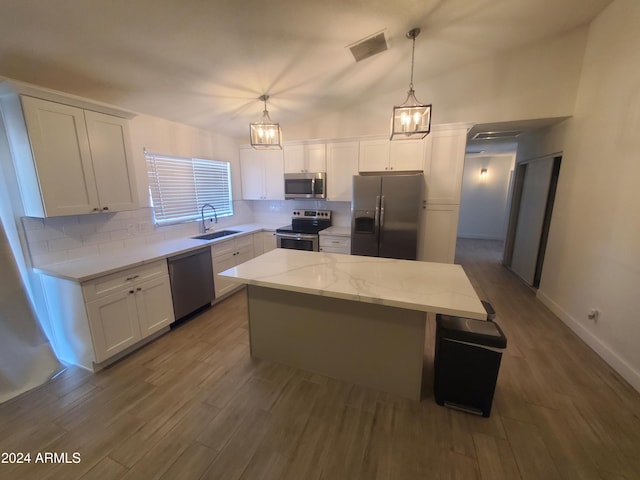 kitchen with pendant lighting, a kitchen island, white cabinetry, and appliances with stainless steel finishes