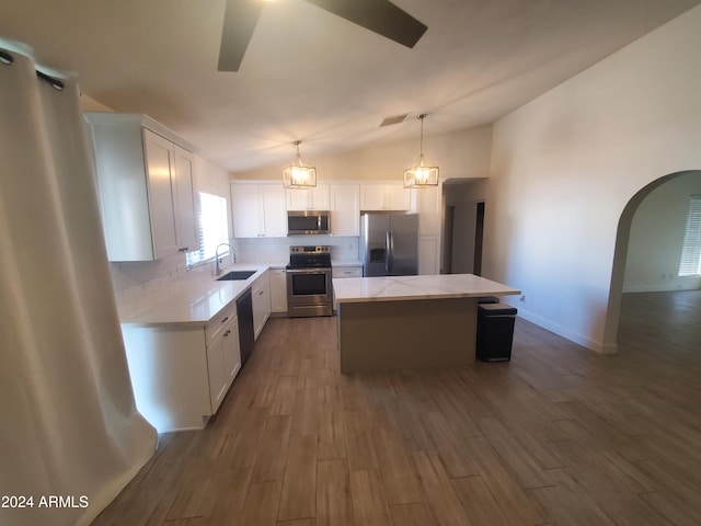 kitchen with appliances with stainless steel finishes, a center island, dark hardwood / wood-style floors, white cabinetry, and lofted ceiling