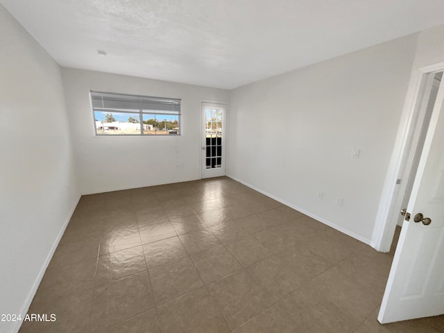 empty room featuring dark tile patterned floors