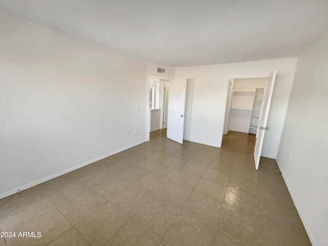 unfurnished bedroom featuring a closet and a spacious closet