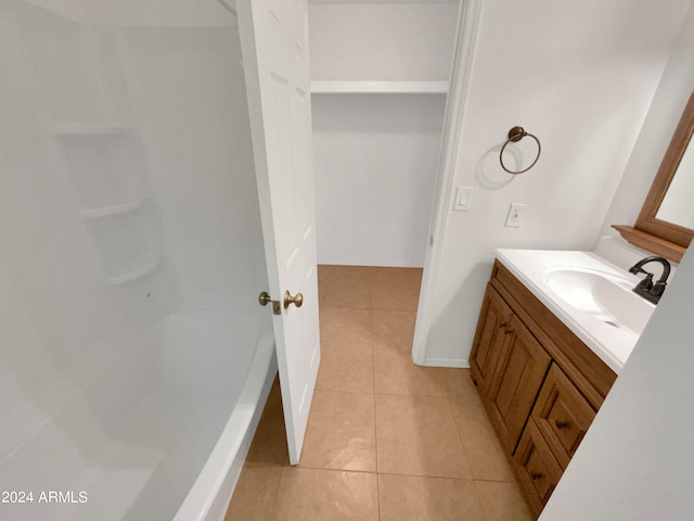 bathroom with tile patterned flooring, vanity, and plus walk in shower