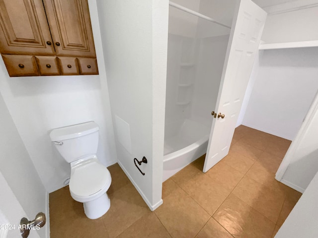 bathroom with washtub / shower combination, toilet, and tile patterned floors