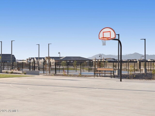 view of basketball court featuring a mountain view, community basketball court, and fence