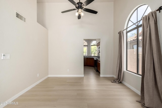 319 N Riata St, Gilbert, AZ 85234 - unfurnished room featuring ceiling fan, light wood finished floors, and a high ceiling