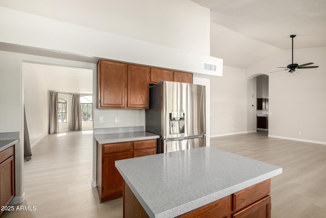 319 N Riata St, Gilbert, AZ 85234 - kitchen with stainless steel fridge, light wood finished floors, a ceiling fan, arched walkways, and open floor plan