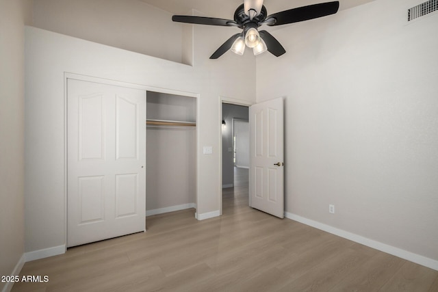 319 N Riata St, Gilbert, AZ 85234 - unfurnished bedroom with light wood-style floors, a closet, a towering ceiling, and a ceiling fan
