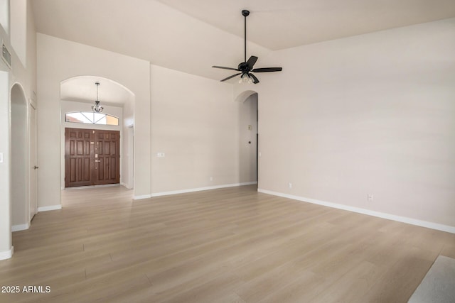 319 N Riata St, Gilbert, AZ 85234 - unfurnished living room with arched walkways, light wood-style floors, a ceiling fan, and high vaulted ceiling