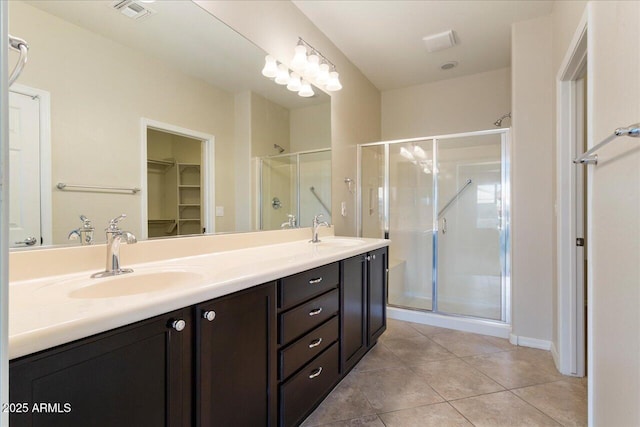 bathroom with tile patterned flooring, vanity, and walk in shower