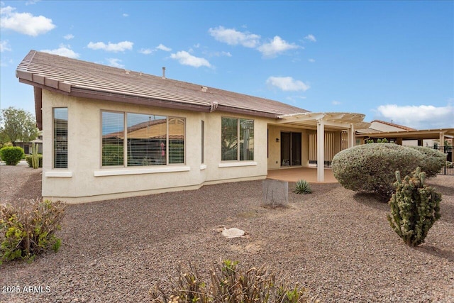 back of property with a pergola and a patio