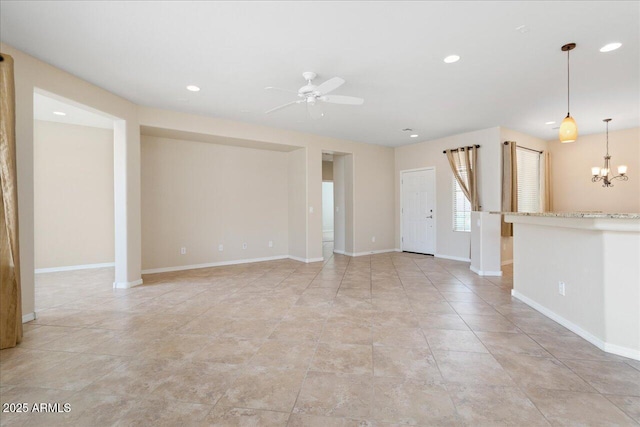 empty room featuring ceiling fan with notable chandelier