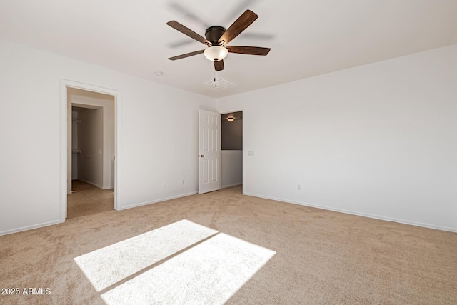 unfurnished bedroom with light colored carpet, a spacious closet, and ceiling fan