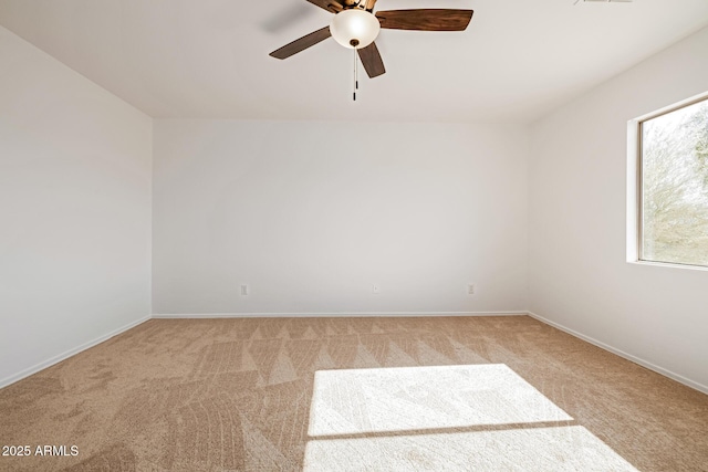 spare room with ceiling fan and light colored carpet