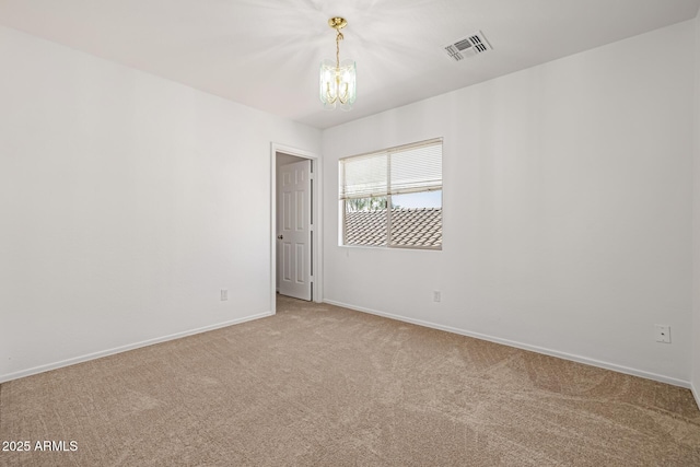 spare room with a notable chandelier and carpet flooring