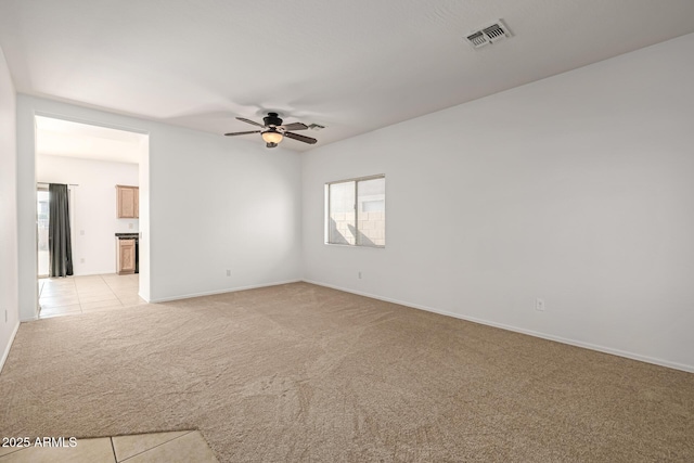 empty room featuring light carpet, a healthy amount of sunlight, and ceiling fan