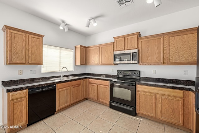 kitchen featuring black appliances, light tile patterned floors, and sink