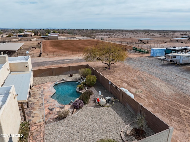 view of swimming pool featuring a rural view