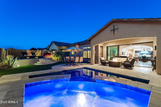 view of swimming pool with a jacuzzi, a patio area, and an outdoor living space with a fire pit