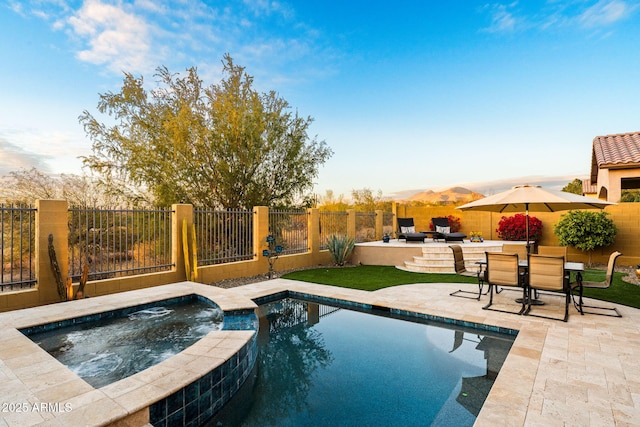 view of pool with an in ground hot tub, a mountain view, and a patio