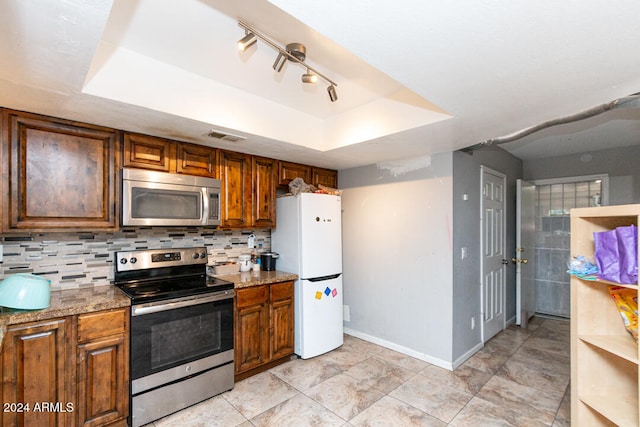 kitchen featuring light stone countertops, appliances with stainless steel finishes, and a tray ceiling