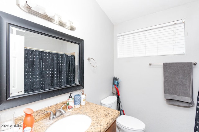 bathroom featuring walk in shower, vanity, vaulted ceiling, and toilet