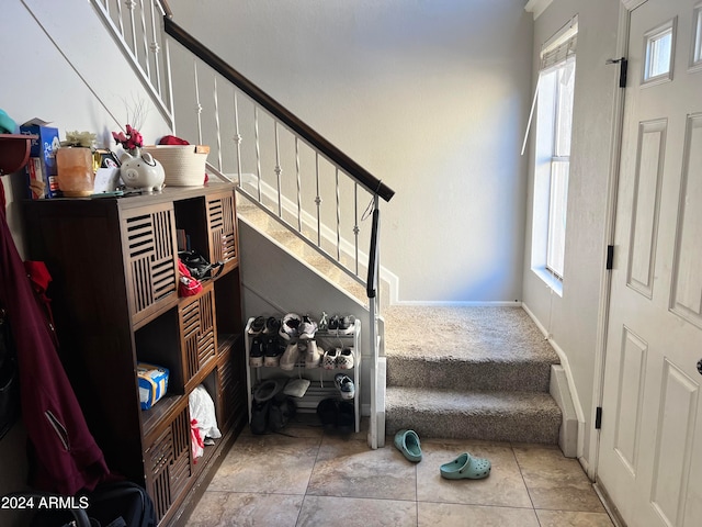 staircase with tile patterned floors and a wealth of natural light