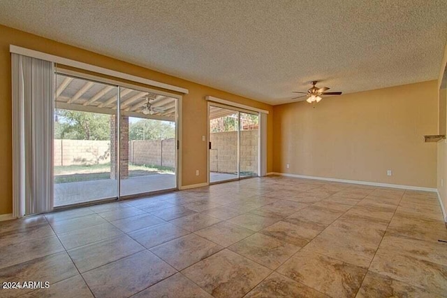 unfurnished room with ceiling fan, light tile patterned flooring, and a textured ceiling