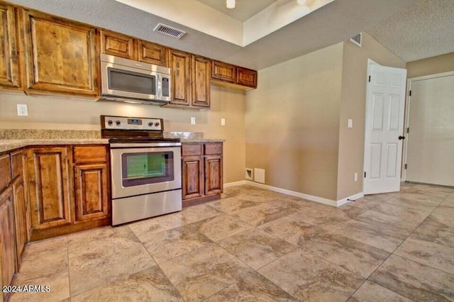 kitchen with stainless steel appliances and a textured ceiling