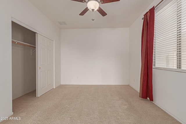 unfurnished bedroom with light carpet, ceiling fan, and a closet